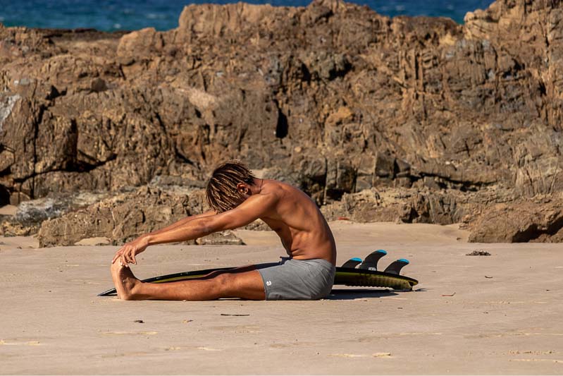 a surfer practicing yoga
